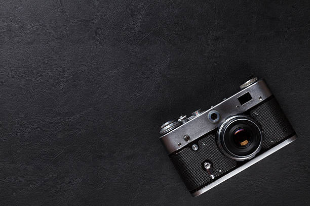 istock Vintage film camera over leather desk table 491620888