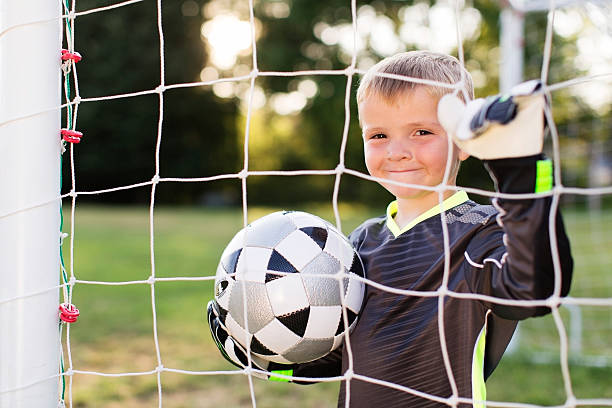 istock Young Boy Soccer Player Stands in Goal 491621158