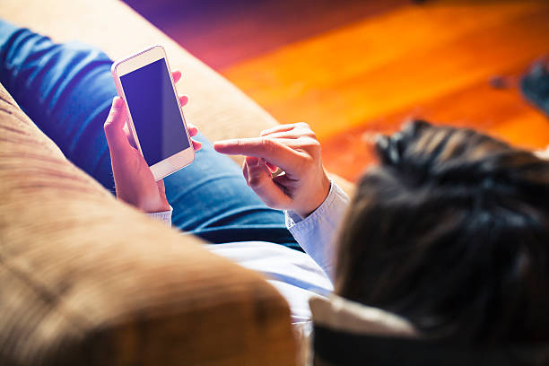 istock Woman touching mobile screen with finger, laying at home. 491628854