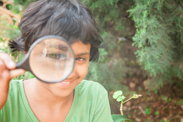 istock Elementary age girl enjoys discovering nature. Magnifying glass. Eye. 491630052