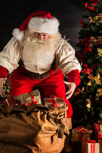 istock Santa Claus opening his sack and taking gifts 491633162