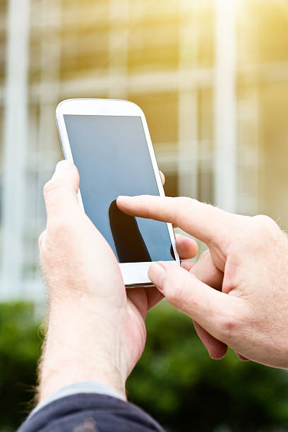 istock Male hand tapping smartphone screen in city setting 491635194