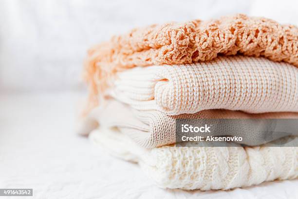 Pila Di Beige Woolen Vestiti Su Sfondo Bianco - Fotografie stock e altre immagini di Maglione - Maglione, Abbigliamento, Cardigan - Top