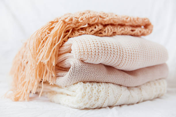 istock Pile of beige woolen clothes on a white background. 491643572