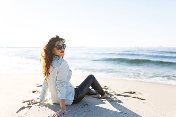 istock Woman sitting on the beach 491644410