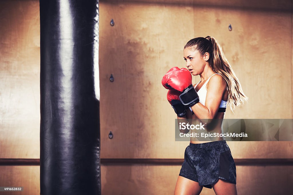Beautiful Fitness Woman Boxing with Red Gloves Beautiful Woman with the Red Boxing Gloves. Attractive Female Boxer Training. Boxing - Sport Stock Photo