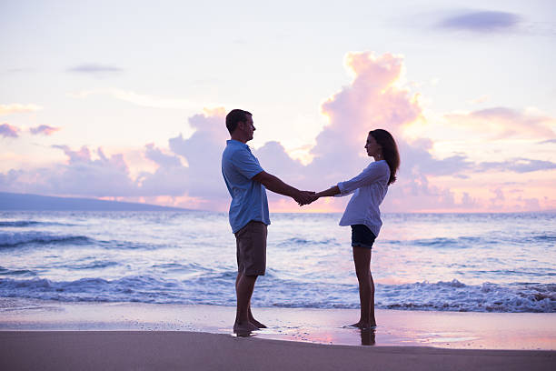 istock Lovers Walking on the Beach at Sunset on Vacation 491654332