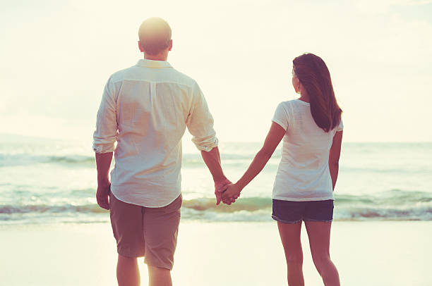istock Couple Walking along the Ocean at Sunset 491654514