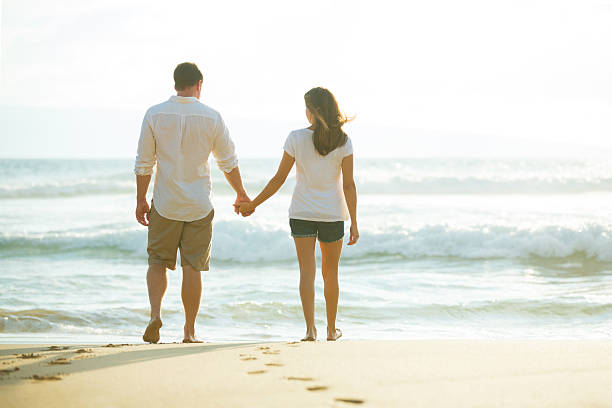 istock Couple Walking along the Ocean at Sunset 491654562