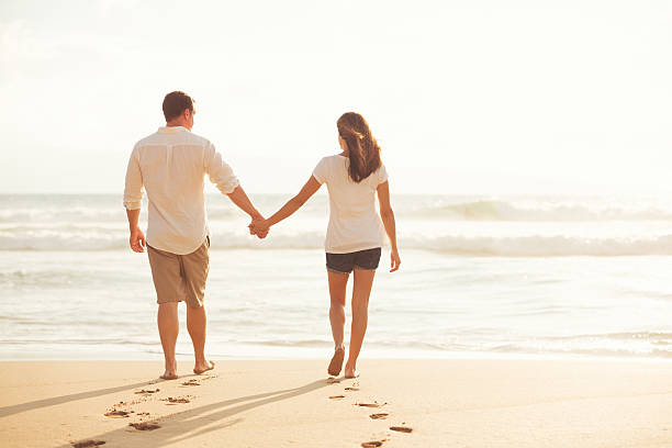 istock Couple Walking along the Ocean at Sunset 491654602