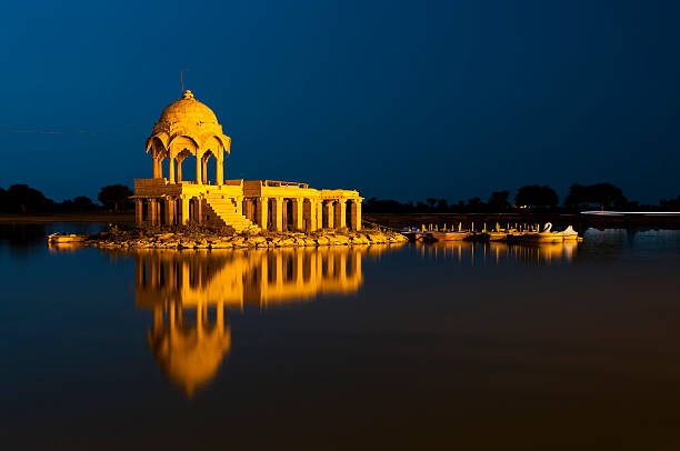 illuminé bâtiment du réservoir gadsisar lac, rajastan jaisalmer, inde - ancient architecture asia asian culture photos et images de collection