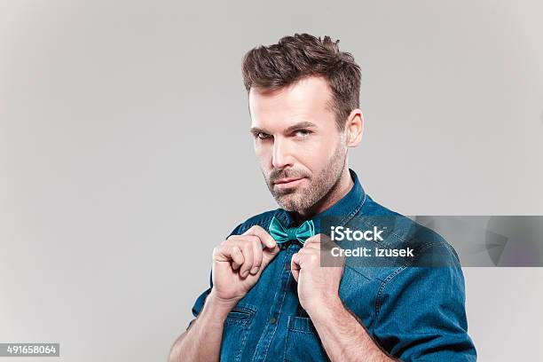 Portrait Of Handsome Man Wearing Jeans Shirt And Bow Tie Stock Photo - Download Image Now