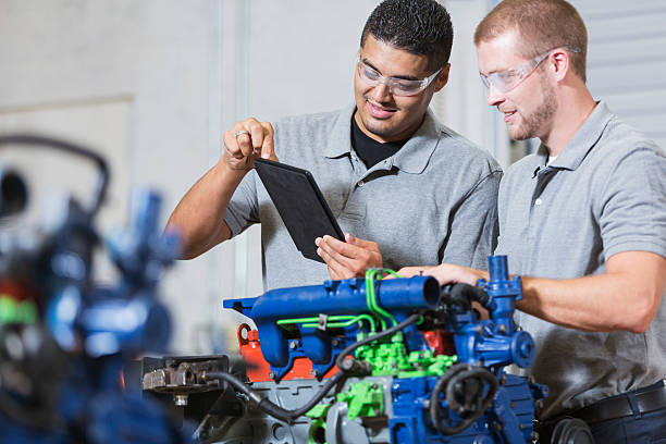istock Two multi-racial men in auto mechanic school with engine 491669096