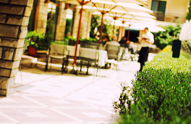 Garden in a restaurant in the spa resort in the Rhodope Mountains, Velingrad, Bulgaria.Waiter under umbrellas - defocused in background.