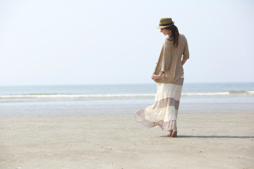 Rear view portrait of a beautiful woman walking on the beach