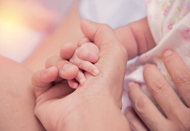 istock New born baby hand in mom palm. 491672072