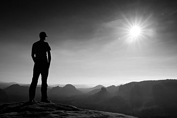 istock Alone hiker in white shirt and cap stand on rock 491681682