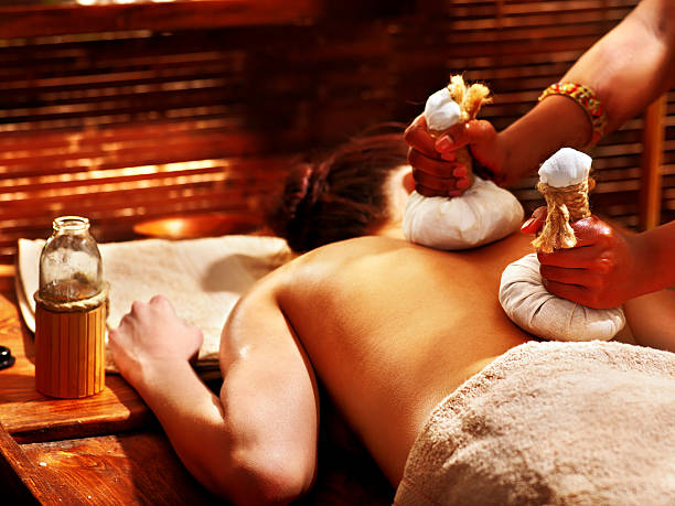mulher tendo massagem com emplasto. - ayurveda massaging spa treatment wellbeing - fotografias e filmes do acervo