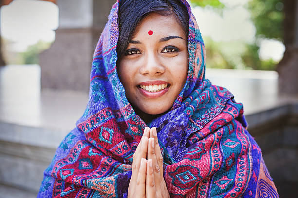 beautiful nepalese woman  performing namaste gesture Young women in colored headscarf keepung her hands in "namaste" hinduism stock pictures, royalty-free photos & images