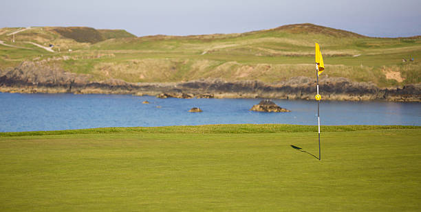 istock Yellow golf course flag flying in the wind links course 491695514