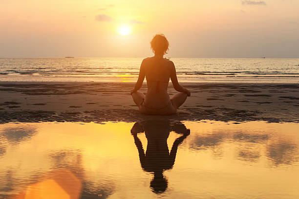 istock Woman practicing yoga on the beach at amazing sunset. 491697892