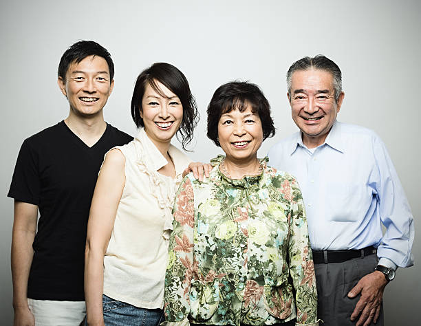 Two generation japanese family Studio portrait of a japanese or asian two generation family. 4 members: old parents and mid age son and daughter. Horizontal color image from a medium format digital camera. Sharp focus on eyes. fine art portrait photos stock pictures, royalty-free photos & images