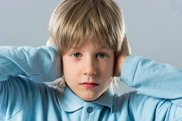 istock Little boy covering his ears and looking at camera. 491700102