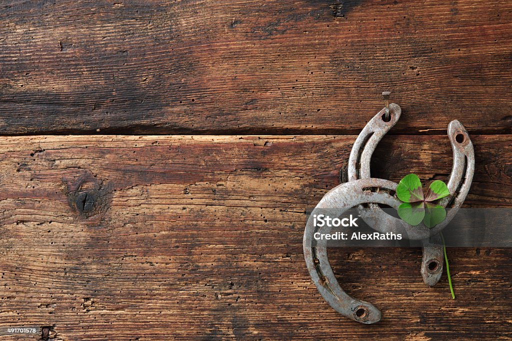 St. Patricks day, lucky charms St. Patricks day, lucky charms. Two horseshoes with a four leaved clover on wooden board Horseshoe Stock Photo