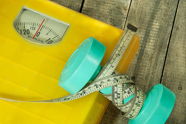 istock dumbbells and weight scale machines 491702301