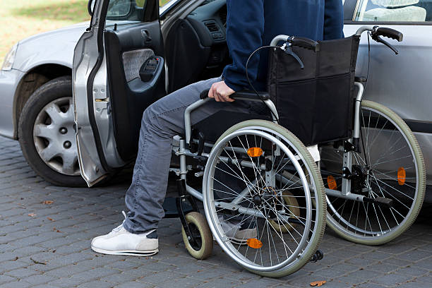 istock Man in wheelchair next to car 491704513
