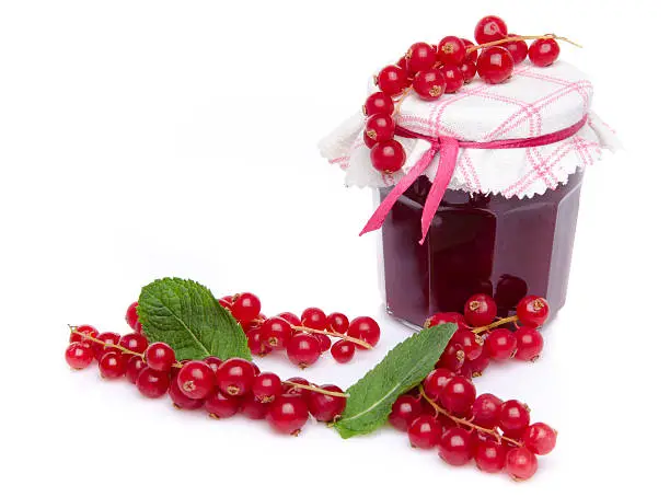 Jar of redcurrant jam with fresh redcurrants and mint, isolated on white