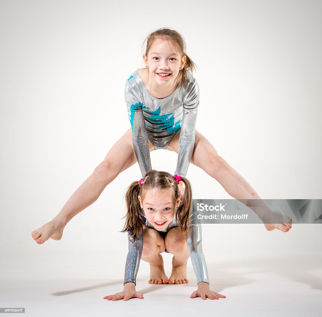 Sporting sisters Two nice girls in gymnastic leotards posing on a white background Twin Stock Photo