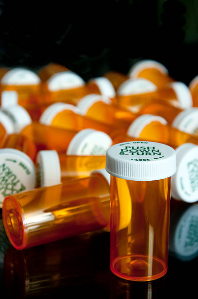 istock Single prescription bottle reflected with vials in background 491707181