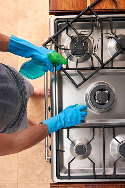 istock Man in the kitchen cleaning stove 491710026
