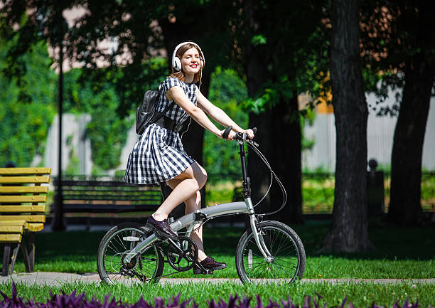 istock Young woman rides bicycle in the park 491713246