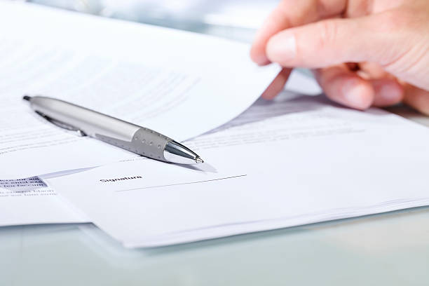 Close-up of a silver pen with documents. stock photo
