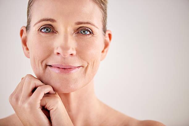 keeping her skin looking great with good beauty habits - mature woman stockfoto's en -beelden