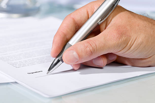 istock Close-up shot of hand signing a document 491713996