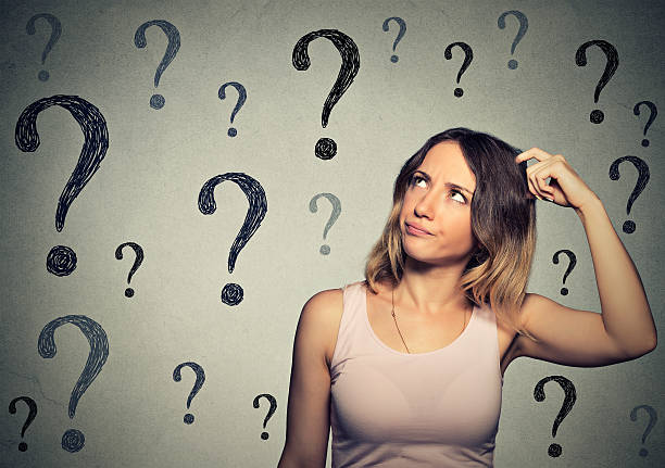 istock Thinking woman looking up at many question marks 491725348
