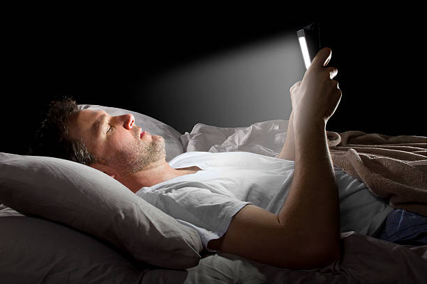istock Male in Bed Browsing the Internet with a Tablet 491725393