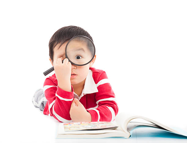 istock surprised kid is holding magnifying glass 491725905