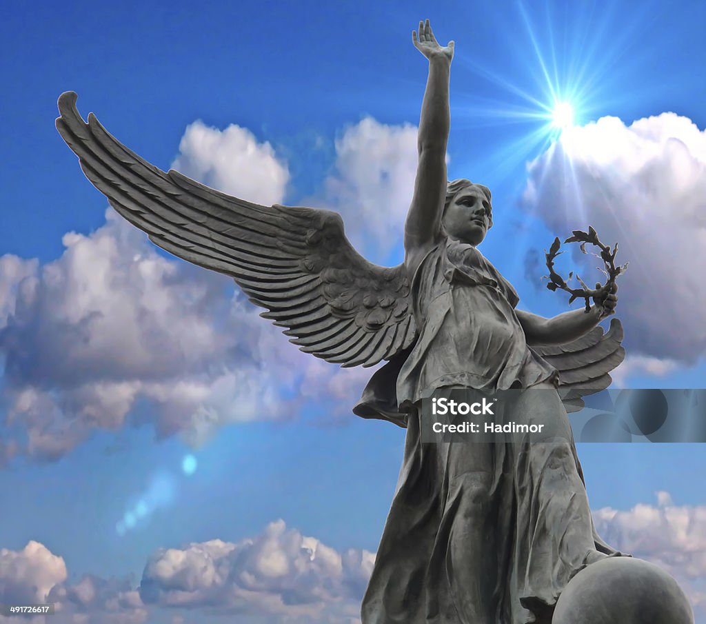 Statue in the blue sky. Statue in sunny day in Montreal park (Parc Jeanne- Manc), hands up and wings open to fly. Angel Stock Photo