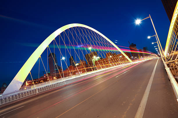 istock Arc bridge girder highway car light trails city night landscape 491727181
