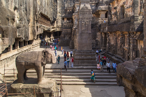 Ellora, India - January 14, 2015: North side of Kailasa temple part of Ellora Caves, with people sightseeing. Also known as Kailasanatha temple one of biggest rock-cut ancient Hindu temples.