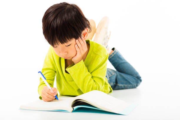 kleine junge studie auf der etage - reading and writing little boys reading asian ethnicity stock-fotos und bilder