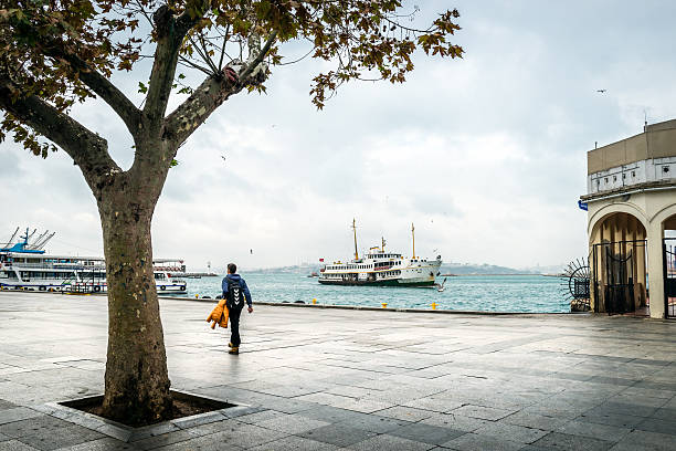 Kadikoy port and ferry boat in Istanbul, Turkey Istanbul, Turkey - September 30, 2015 : Boy is walking at the Kadikoy port in Istanbul. quayside photos stock pictures, royalty-free photos & images