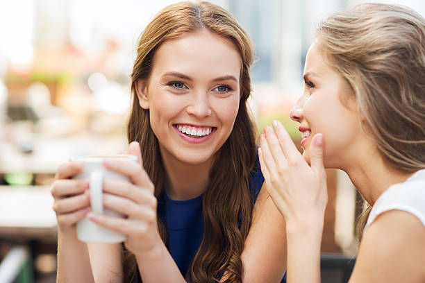 istock young women drinking coffee and talking at cafe 491730566