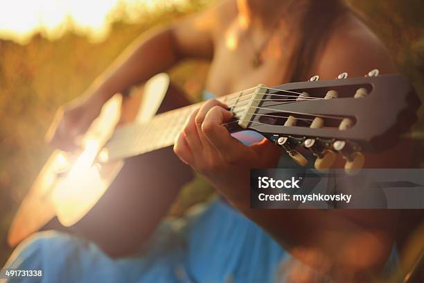 Beautiful Woman Playing The Acoustic Guitar In Field Stock Photo - Download Image Now