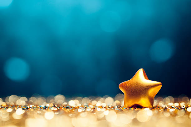 Christmas Star - Glitter Lights Bokeh Defocused Decoration Gold Blue Glittery christmas decorations. Defocused lights in the background. Photo captured with a Canon EF 100mm F/2.8L at f4.0.  christmas star shape christmas lights blue stock pictures, royalty-free photos & images