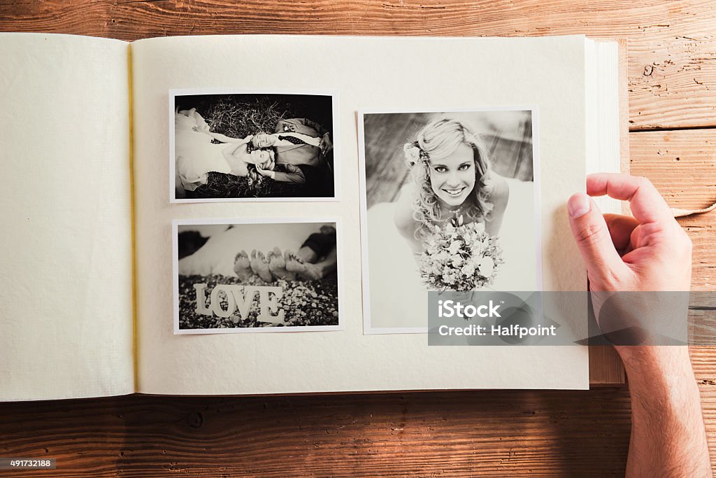 Wedding photo Picture of bride and groom in photo album. Studio shot on wooden background. Photo Album Stock Photo